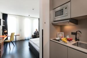 cocina con fregadero y encimera con microondas en Brera Serviced Apartments Munich Schwabing en Múnich