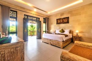 um quarto com uma cama grande e uma varanda em AlamGangga Villas Tirta Gangga em Tirtagangga