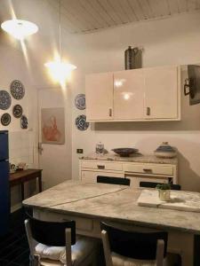 a kitchen with white cabinets and a counter top at Lucio Fontana's experience in Comabbio