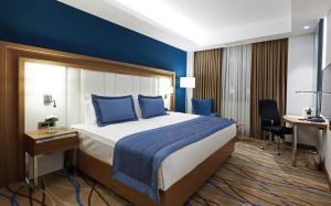 Habitación de hotel con cama y escritorio en Dedeman Kayseri en Kayseri