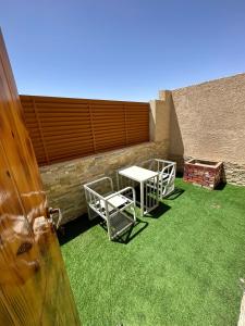 a patio with a table and chairs on the grass at Leen Serviced Apartments in Khamis Mushayt