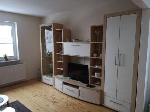 een woonkamer met een tv en een grote witte kast bij Ferienhaus für 4 Personen Waldeck Edersee in Waldeck