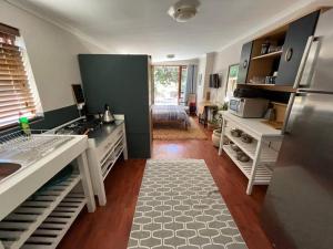 a kitchen with a stove and a refrigerator at Pinchushion Cottage Fish Hoek in Fish hoek