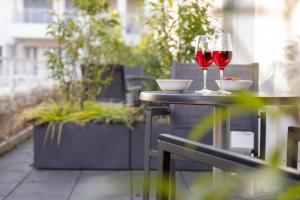 dos vasos de vino tinto sentados en una mesa en Brera Serviced Apartments Munich Schwabing, en Múnich