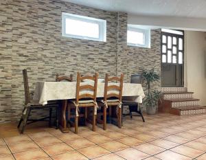 comedor con mesa, sillas y pared de ladrillo en Casa planta baja en la playa, en Vigo