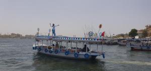 ein Boot mit einer Statue auf dem Wasser in der Unterkunft Nile Sunrise Felucca Boat Private Rental in Luxor