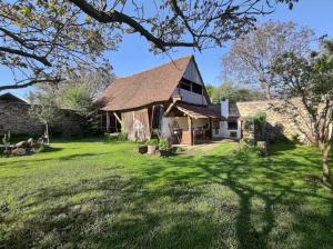 une ancienne grange en pierre avec une pelouse dans l'établissement Casa din Şona, à Şona