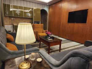 شاطيء الحياه للشقق الفندقية في جدة: غرفة معيشة مع كنب وطاولة مع مصباح