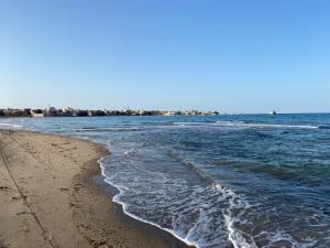 a beach with the ocean and the shoreline w obiekcie SWEET ESCAPE w mieście Al-Kusajr