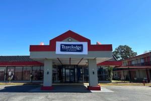 a store with a sign on the front of it at Travelodge by Wyndham Lumberton in Lumberton