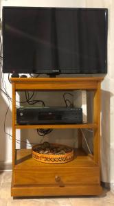 a flat screen tv on a wooden tv stand at Oliva Seaside Apartments in Oliva