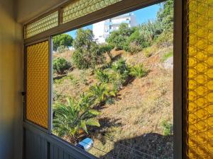 een raam met uitzicht op een heuvel vanuit een huis bij Fonte Park in Setúbal