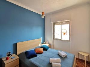 een blauwe slaapkamer met een bed en een raam bij Fonte Park in Setúbal