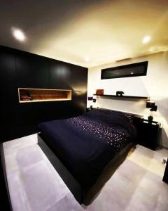 a bedroom with a black bed and a fireplace at Superbe appartement chic et design in Seraing