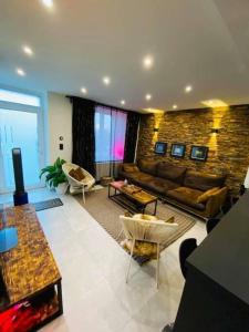 uma ampla sala de estar com um sofá e cadeiras em Superbe appartement chic et design em Seraing