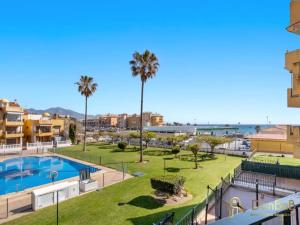 ośrodek z basenem i palmami w obiekcie Apartamento cerca de la playa en las lagunas de Mijas w mieście Fuengirola