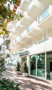 an image of a building with plants in front of it at Hotel Lampara in Lignano Sabbiadoro