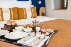 ein Tablett mit Lebensmitteln, Küchenutensilien und einem Tee-Set auf dem Bett in der Unterkunft Cueillette in Altillac