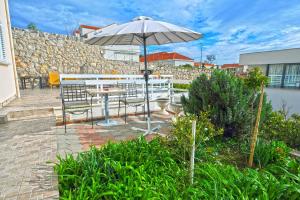 a patio with a table and an umbrella at Villa Katarina in Dubrovnik