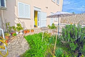 a patio with an umbrella and plants in front of a house at Villa Katarina in Dubrovnik