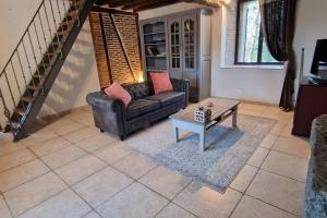 sala de estar con sofá y mesa de centro en Jardins de Mélusine - Maison en pierres 