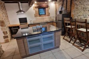 a kitchen with a large island with blue cabinets at Jardins de Mélusine - Maison en pierres 