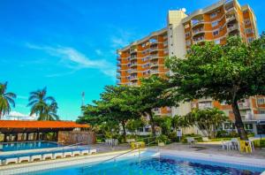 a hotel with a swimming pool in front of a building at Império Romano - Splash e Acqua Park in Caldas Novas