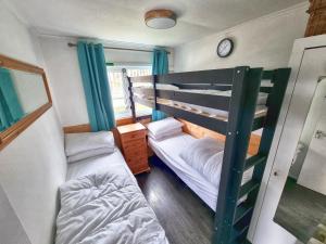 a bedroom with two bunk beds and a window at Caswell Beach Chalet 70 located in Gower Peninsula in Swansea