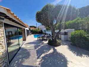 a patio with a tree and a swimming pool at Villa Casa Cis in Calella de Palafrugell