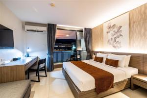 una camera d'albergo con letto, scrivania e computer di Citrus Patong Hotel by Compass Hospitality a Patong Beach