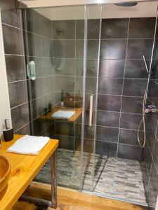 a shower with a glass door in a bathroom at O Lodge in Cleppé