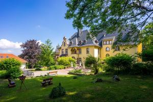 ein großes gelbes Haus mit einem Hof davor in der Unterkunft Hotel Erbprinzenpalais in Wernigerode