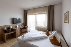 una camera d'albergo con letto e TV di Hotel Turracherhof a Turracher Hohe