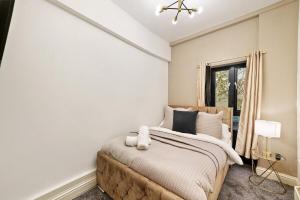 a bedroom with a large bed and a window at Stylish 2BR Luxury Retreat with 65" Smart TV in Kent