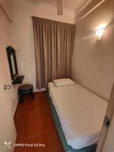 a small bed in a room with a window at Glory beach Penthouse apartment 3bedroom in Port Dickson +29 photos