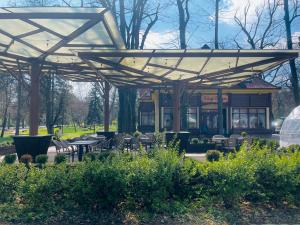 een paviljoen met tafels en stoelen in een park bij Villa Hotel in Debrecen