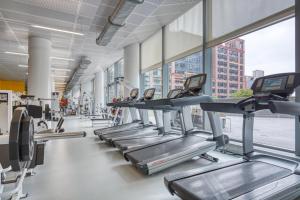 a row of treadmills in a gym at Hells Kitchen 1BR w Doorman nr Central Park NYC-525 in New York