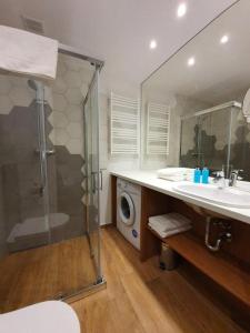 a bathroom with a shower and a sink and a washing machine at Prywatne apartamenty w hotelu - 365PAM in Sarbinowo