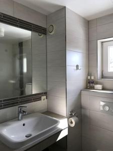 a white bathroom with a sink and a mirror at Charmantes lütt Eckhus Zingst in Zingst