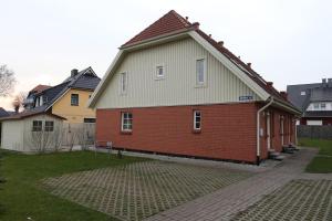 een rood bakstenen huis met een grijs dak bij Charmantes lütt Eckhus Zingst in Zingst