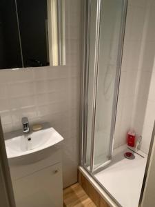 a white bathroom with a shower and a sink at 3 Bedroom Lux Apartment Center in Wrocław +7 photos