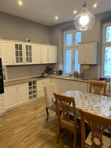 a kitchen with a table and chairs and white cabinets at 3 Bedroom Lux Apartment Center in Wrocław