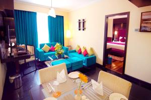 a living room with a table and a blue couch at Sterlings Mac Hotel in Bengaluru
