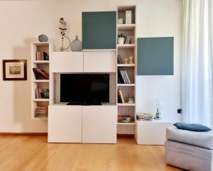 - un salon avec un centre de divertissement blanc et une télévision dans l'établissement Madeleine apartments - Appartamento di charme, à Milan