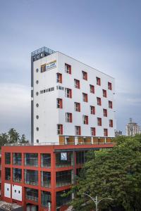 un grande edificio bianco con finestre rosse in cima a un edificio di TERRACE BUSINESS HOTEL KOZHIKODE a Kozhikode