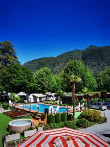 um resort com piscina e montanhas ao fundo em Camping Melezza em Losone