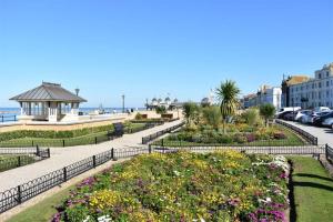 a view of a park with flowers and the beach at Luxury 1 bed studio at Florence House, in the centre of Herne Bay and 300m from beach in Herne Bay
