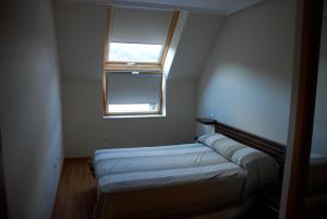 Habitación pequeña con cama y ventana en APARTAMENTO ESPASANTE, en Porto de Espasante