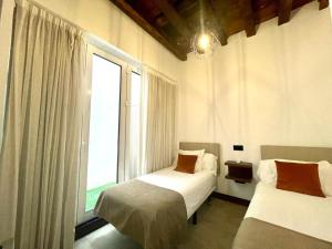 um quarto com 2 camas e uma grande janela em Eva Recommends Triana em Sevilha