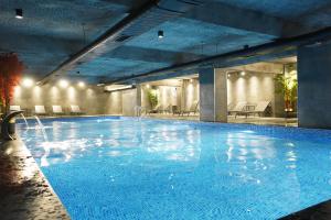 a large swimming pool with blue water in a building at Elifim Resort Hotel 